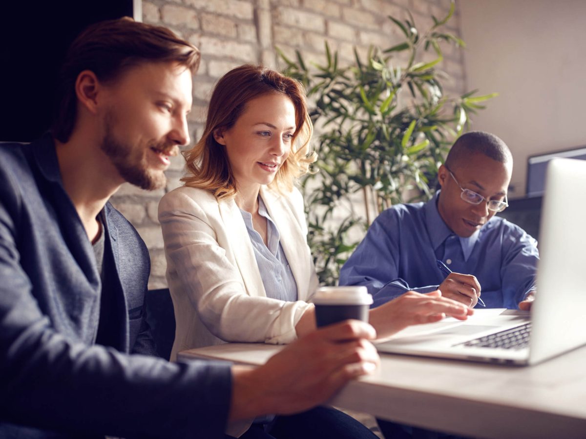 Business people working at desk on laptop in office