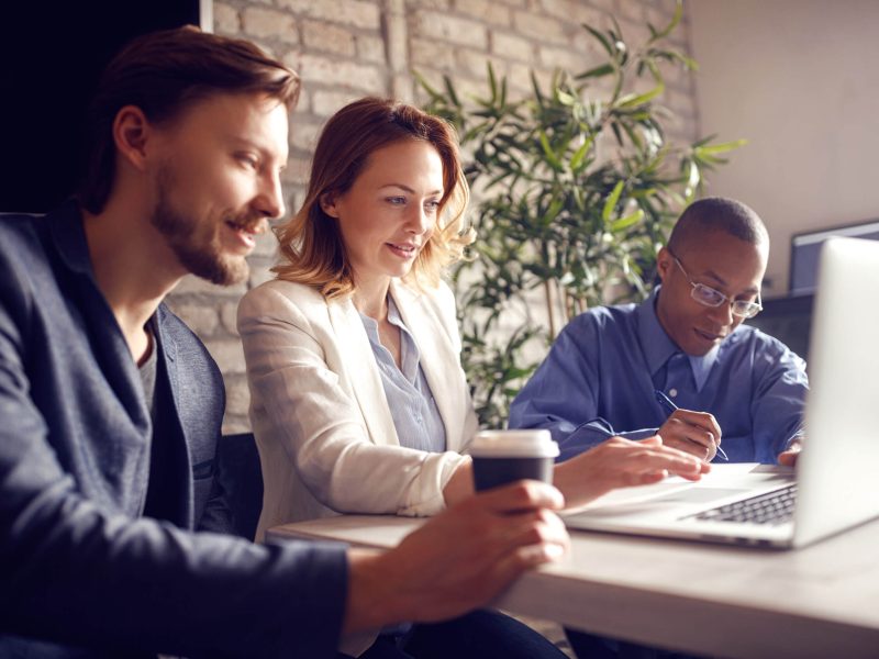 Business people working at desk on laptop in office