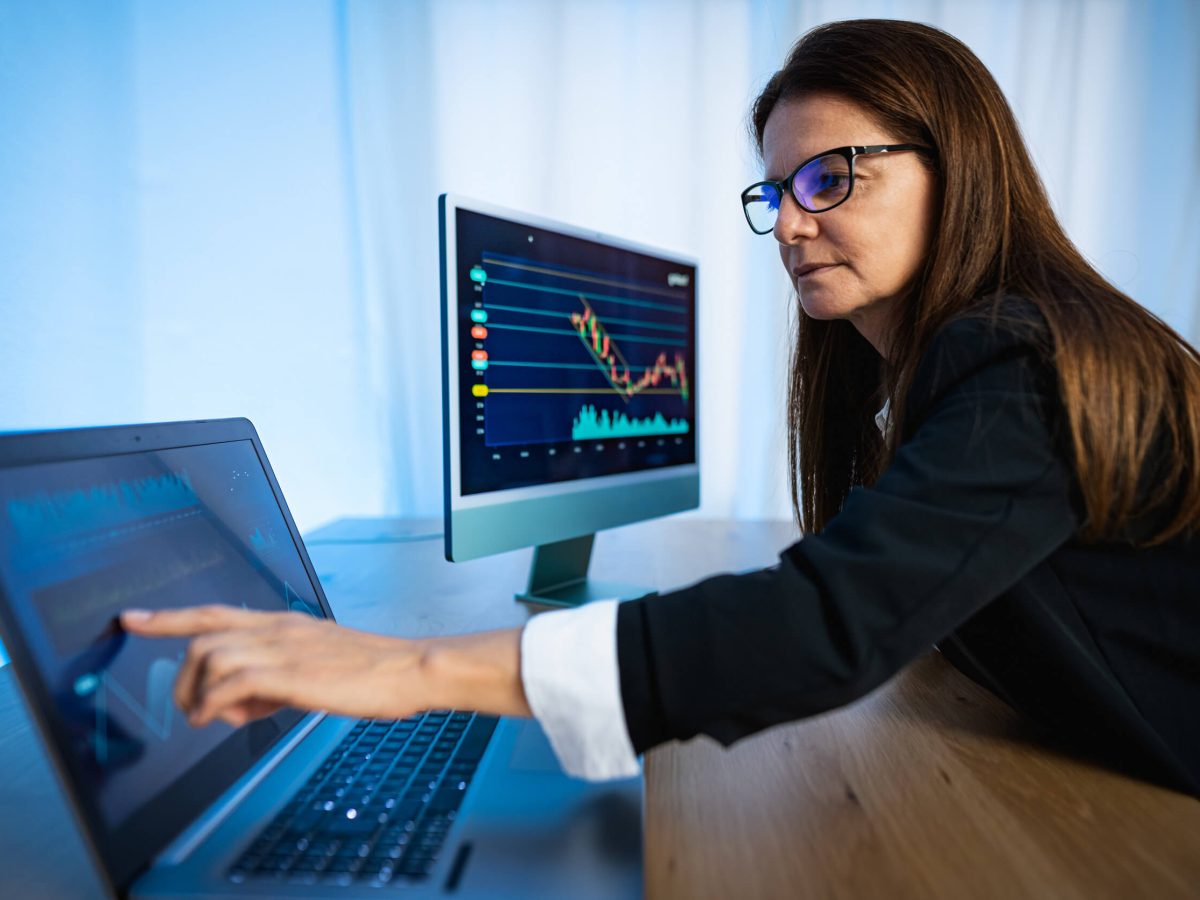 Woman looking at data on computer screens