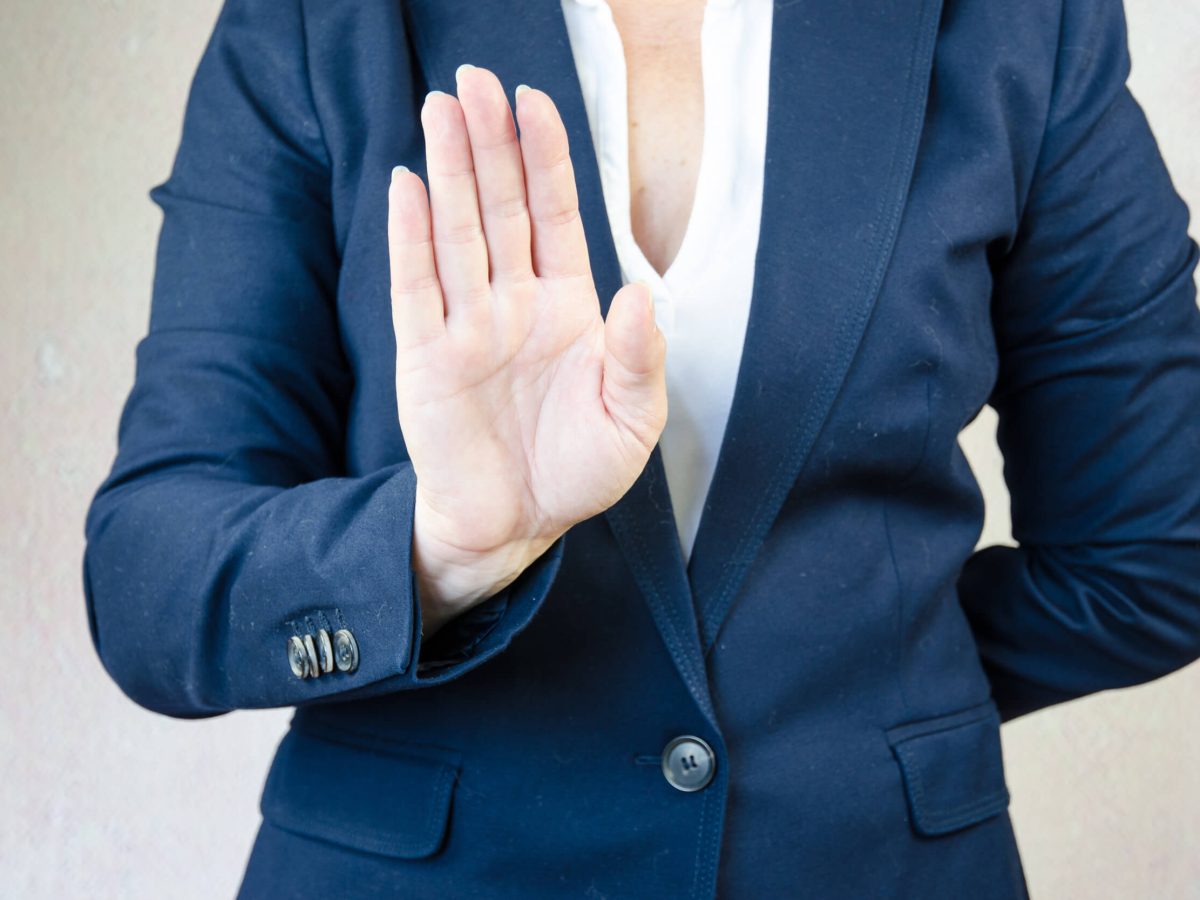 Woman holding her back up in stop gesture