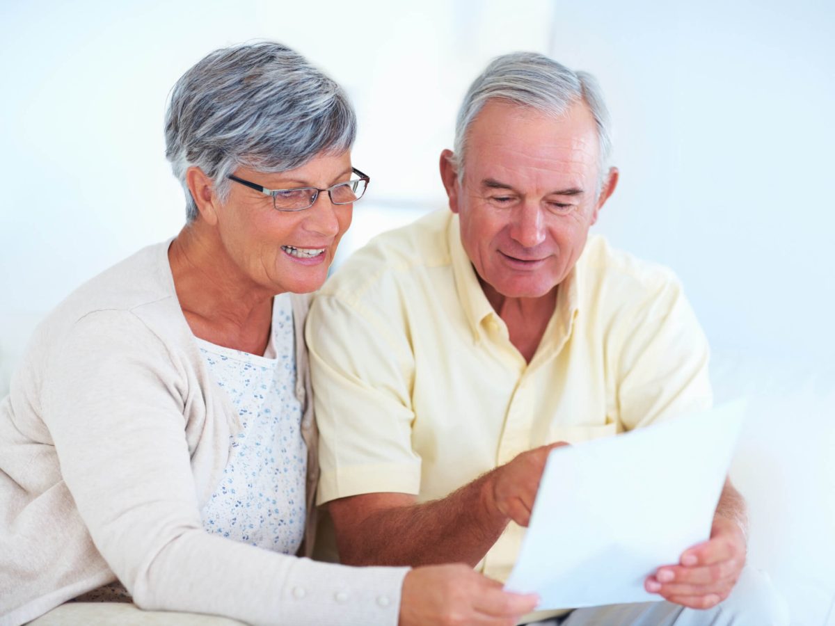 Older couple happily reading a letter